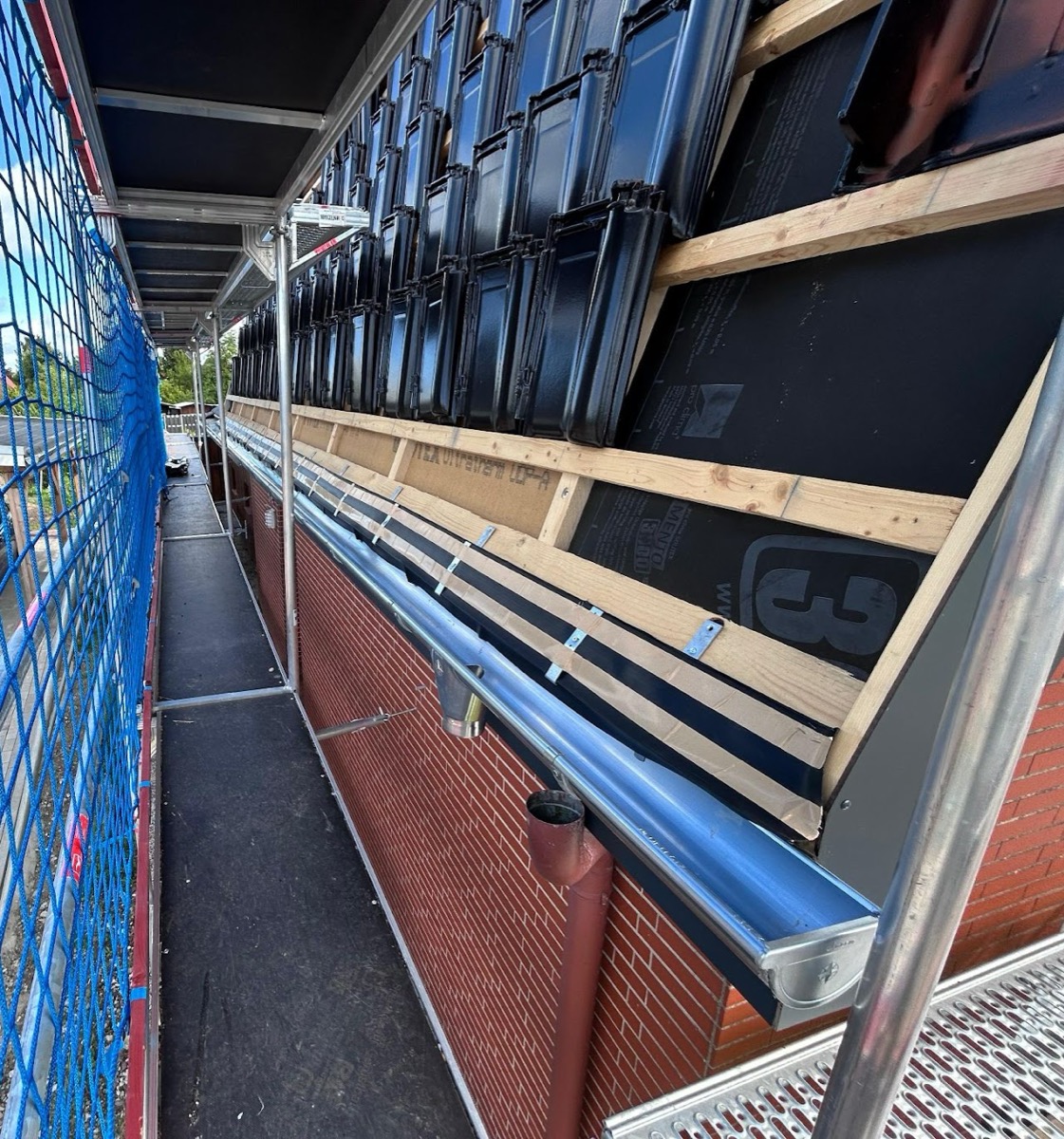 Holzbau und Fassadendetail an einem eingerüsteten Gebäude